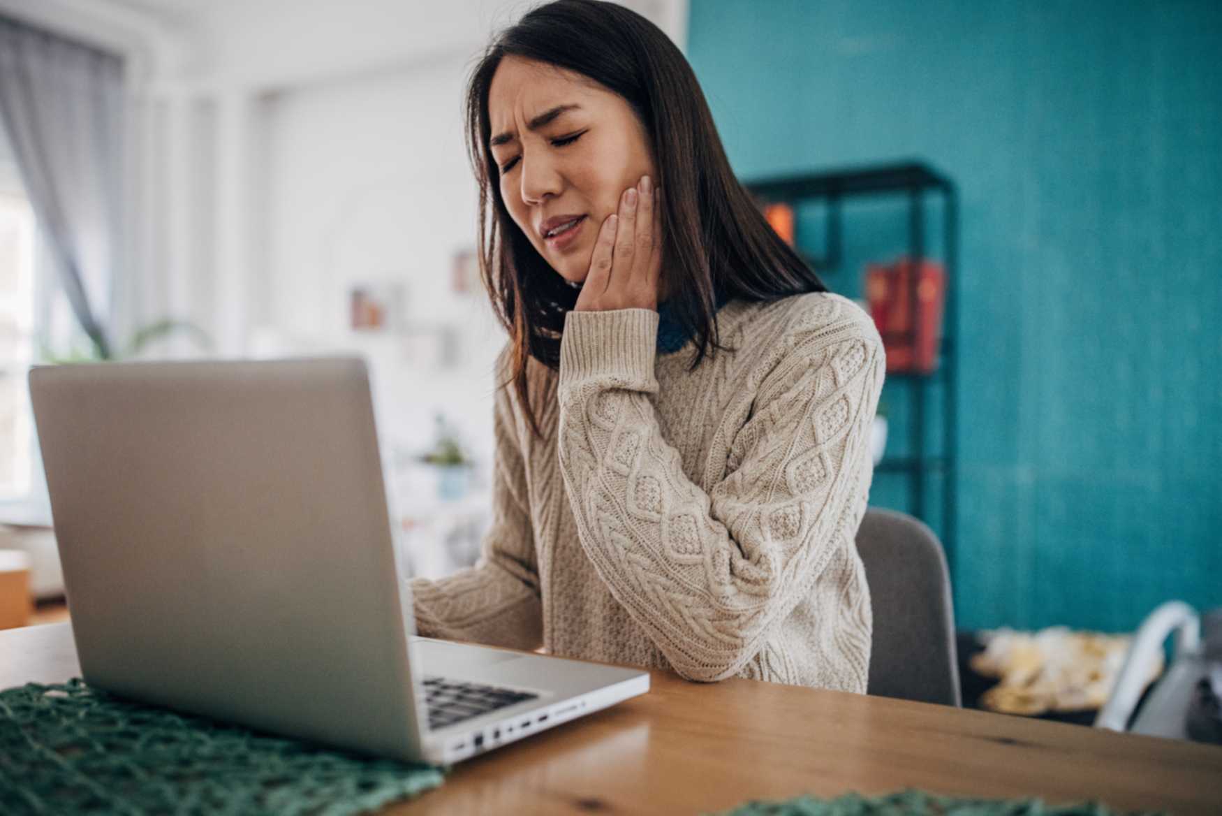 A woman researching ways to treat unbearable tooth pain