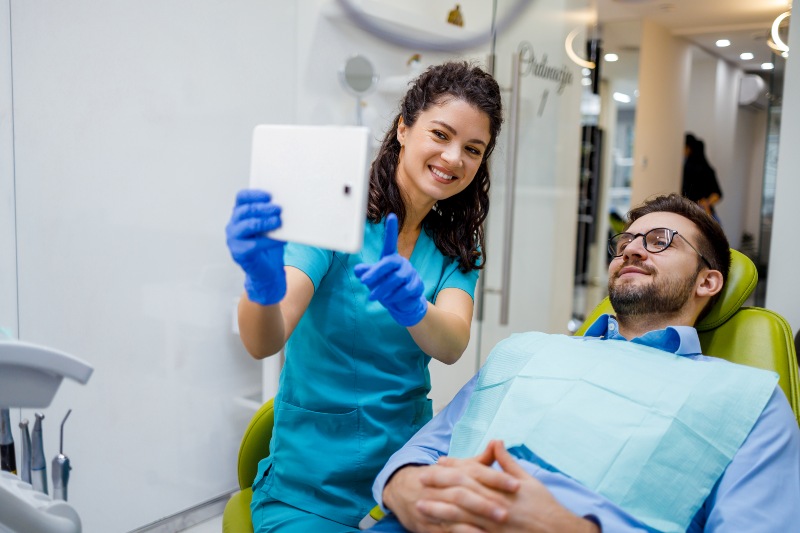 A nurse explaining All‑on‑4 dental implants to a patient seated in a dental chair in San Jose, CA