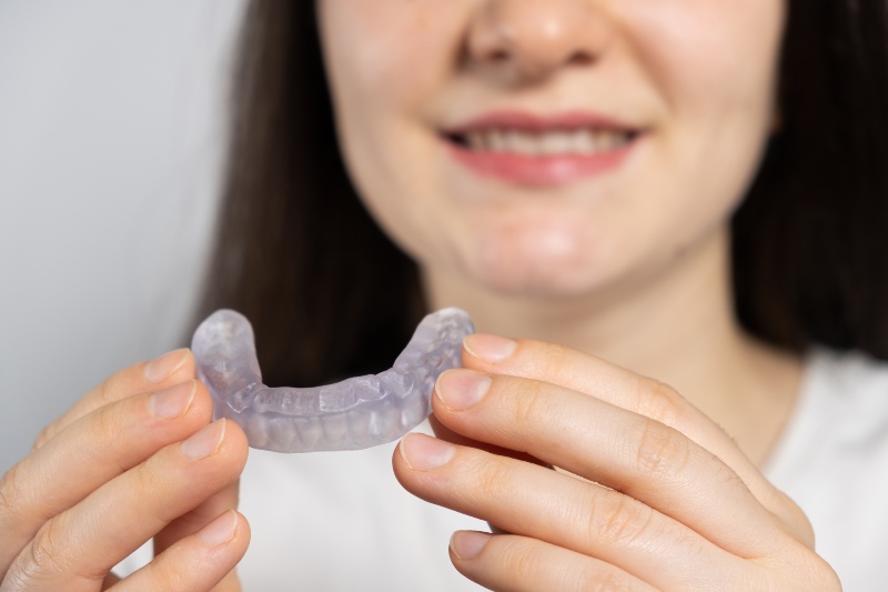 Person holding a custom dental mouthguard for teeth protection in San Jose, CA