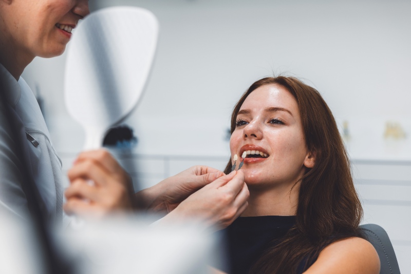 Patient comparing dental veneer shade during cosmetic consultation in San Jose, CA